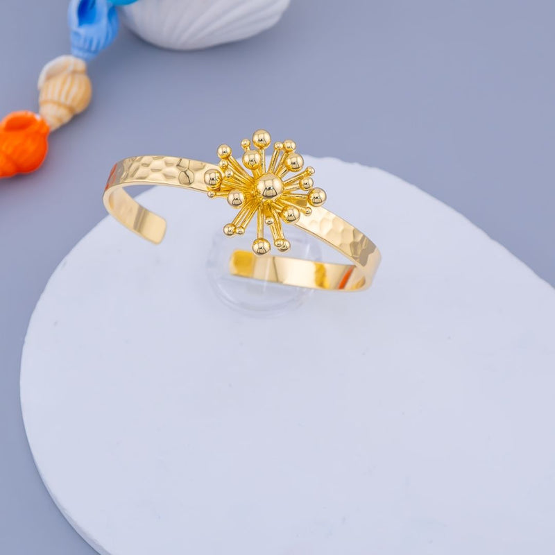 Brazalete chunky en tendencia martillado y decorado con flor baño 18k